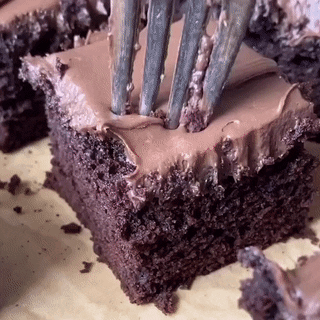 A Close Up Of A Piece Of Chocolate Cake With A Fork Sticking Out Of It GIF