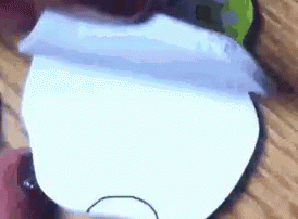A Close Up Of A Piece Of Paper With A Hole In It . GIF