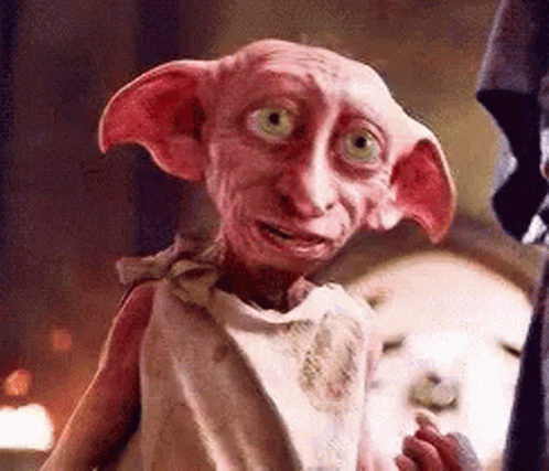 A Close Up Of A Pink Dobby From Harry Potter Standing Next To A Person . GIF