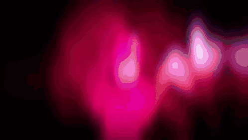 a close up of a pink glowing object with a black background