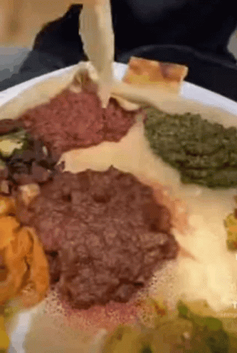 a close up of a plate of food with meat and vegetables on it