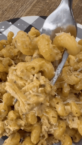 A Close Up Of A Plate Of Macaroni And Cheese With A Fork GIF