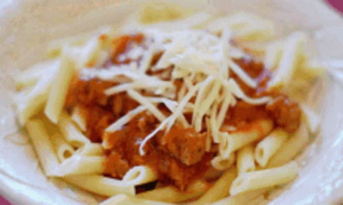 A Close Up Of A Plate Of Pasta With Meat Sauce And Cheese GIF