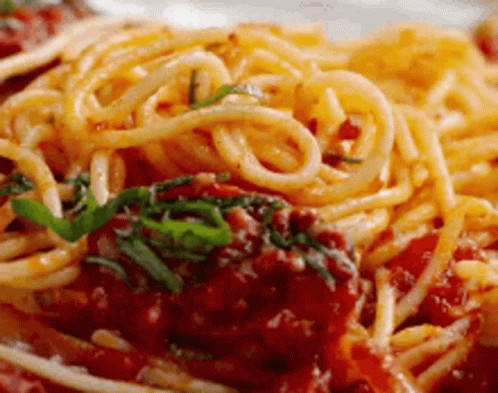A Close Up Of A Plate Of Spaghetti With Tomato Sauce And Meatballs . GIF