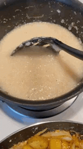 A Close Up Of A Pot Of Soup With A Spoon In It On A Stove . GIF