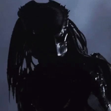 A Close Up Of A Predator 'S Face With A Blurred Background GIF
