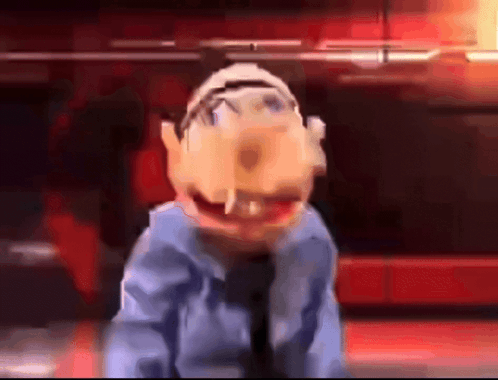 A Close Up Of A Puppet In A Blue Shirt And Tie Making A Funny Face GIF