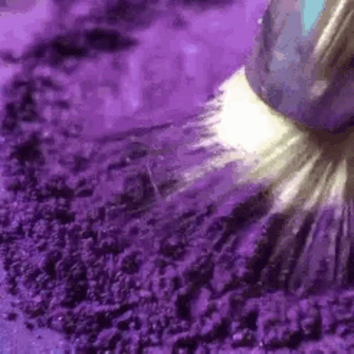 A Close Up Of A Purple Powder With A Brush . GIF