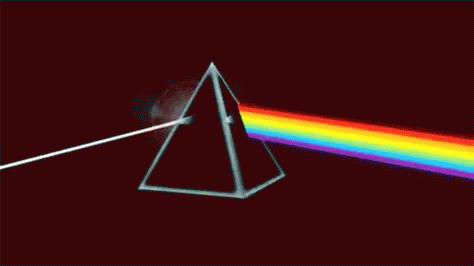 A Close Up Of A Rainbow Colored Light On A Black Background GIF