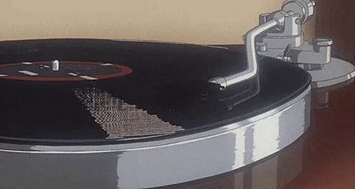 A Close Up Of A Record Player Playing A Record On A Table . GIF