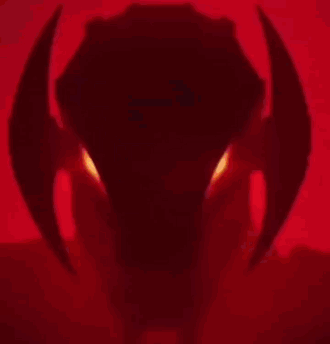 A Close Up Of A Robot 'S Head With Red Eyes . GIF