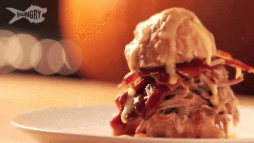 A Close Up Of A Sandwich On A White Plate With The Word Hungry On It GIF