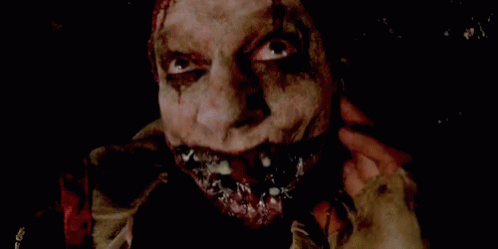 a close up of a scary clown 's face with blood coming out of his mouth .