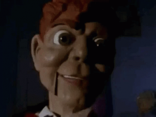 A Close Up Of A Scary Puppet With A Shadow On His Face . GIF