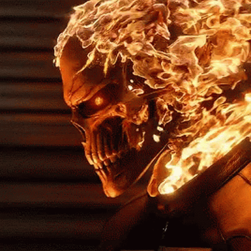 A Close Up Of A Skull With Flames Coming Out Of It 'S Head GIF