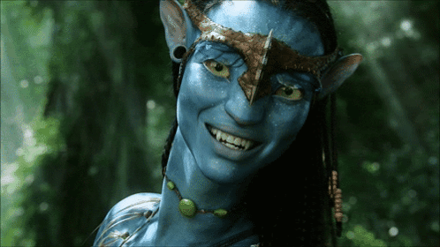A Close Up Of A Smiling Avatar With Blue Skin GIF