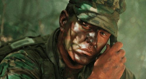 A Close Up Of A Soldier 'S Face With A Camouflage Uniform GIF