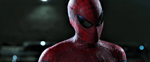 A Close Up Of A Spider Man 'S Face Against A Dark Background GIF