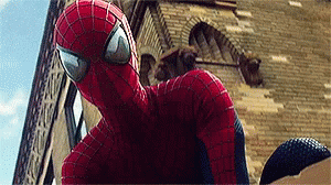 A Close Up Of A Spider Man Standing In Front Of A Building . GIF