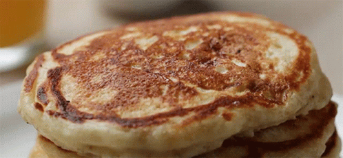 A Close Up Of A Stack Of Pancakes On A Table GIF