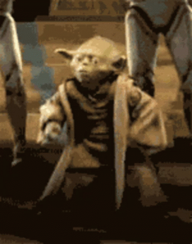 A Close Up Of A Statue Of Yoda Holding A Knife GIF
