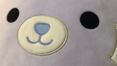 A Close Up Of A Stuffed Animal 'S Face With A Blue Nose GIF