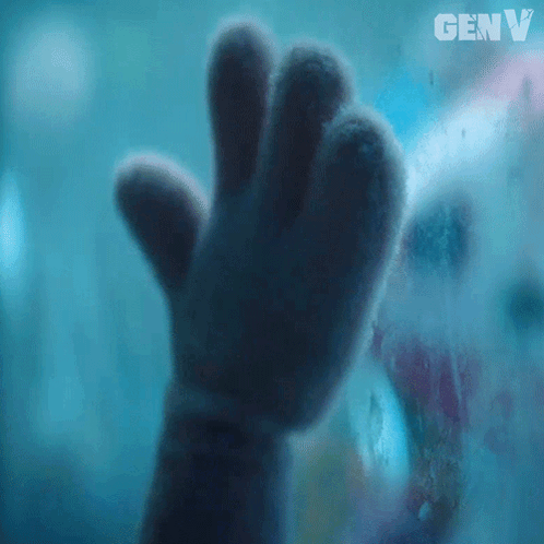 a close up of a stuffed animal 's hand behind a glass with genv written on it