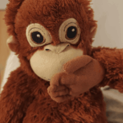 A Close Up Of A Stuffed Monkey Covering Its Mouth With Its Hand GIF