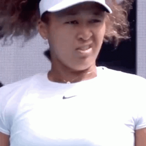 A Close Up Of A Tennis Player Wearing A White Hat And A White Shirt . GIF