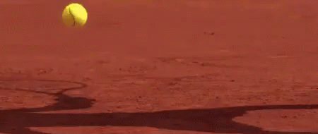 A Close Up Of A Tennis Racket Hitting A Tennis Ball On A Tennis Court . GIF