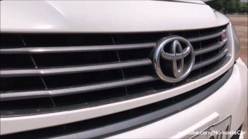 A Close Up Of A Toyota Emblem On A White Car GIF