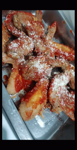 A Close Up Of A Tray Of Food With Sauce And Cheese GIF