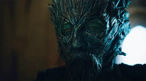 A Close Up Of A Tree Face With A Beard And Green Eyes GIF