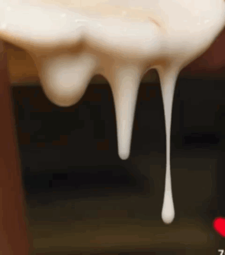 A Close Up Of A White Liquid Dripping From A Bottle GIF