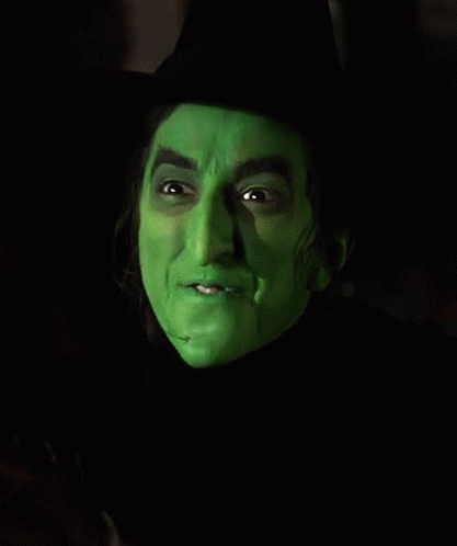A Close Up Of A Witch 'S Face With Green Paint On It . GIF