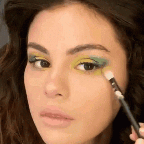 A Close Up Of A Woman Applying Green Eye Shadow GIF