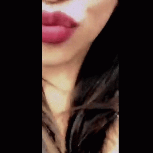 A Close Up Of A Woman Blowing A Kiss With Red Lipstick . GIF