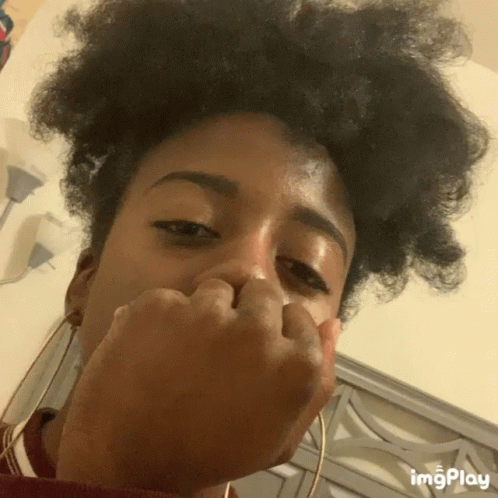 A Close Up Of A Woman Covering Her Nose With Her Hand And The Words Imgplay Below GIF