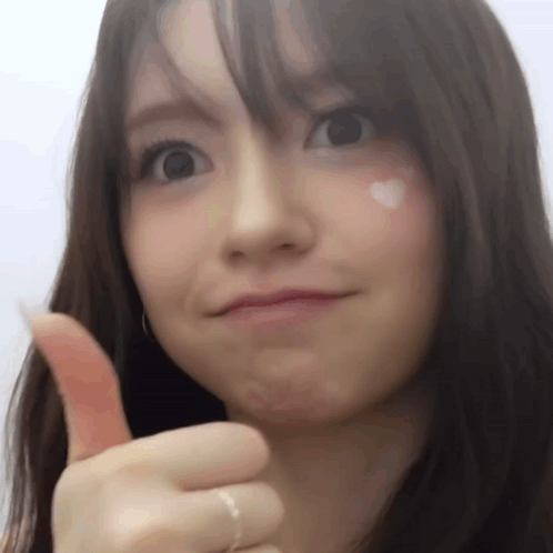 A Close Up Of A Woman Giving A Thumbs Up Sign GIF