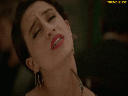 A Close Up Of A Woman Holding A Fork To Her Neck With The Words Trendizisst On The Bottom GIF