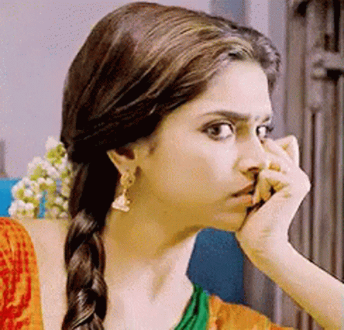 A Close Up Of A Woman Holding Her Nose With Her Hand . GIF