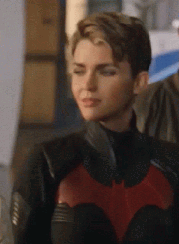 A Close Up Of A Woman In A Batman Costume . GIF