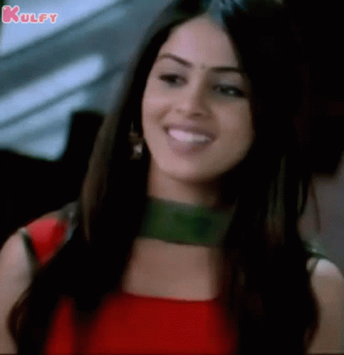 A Close Up Of A Woman In A Red Dress Smiling . GIF