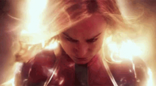 A Close Up Of A Woman In A Superhero Costume Surrounded By Flames . GIF
