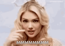A Close Up Of A Woman Making A Funny Face And Pointing At Her Mouth . GIF