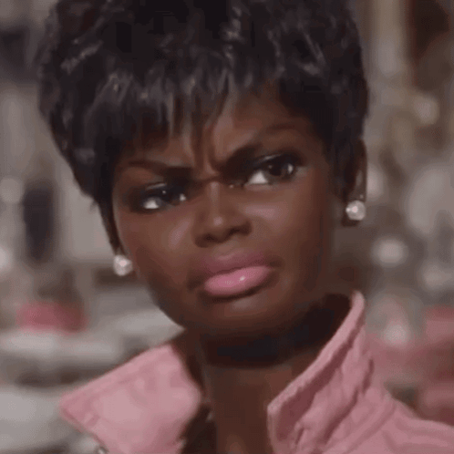 A Close Up Of A Woman Making A Funny Face Wearing A Pink Jacket GIF
