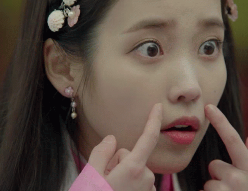 A Close Up Of A Woman Making A Funny Face With Her Fingers GIF