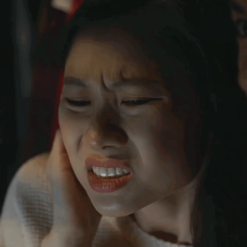 A Close Up Of A Woman Making A Funny Face With Her Hand On Her Ear GIF
