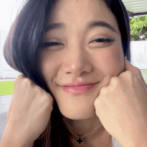 A Close Up Of A Woman Making A Funny Face With Her Hands GIF