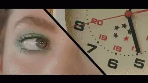 A Close Up Of A Woman 'S Eye Next To A Clock With The Hands On The Numbers 20 And 19 GIF